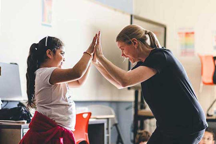 Beth Wright does movement with a female student in the classroom