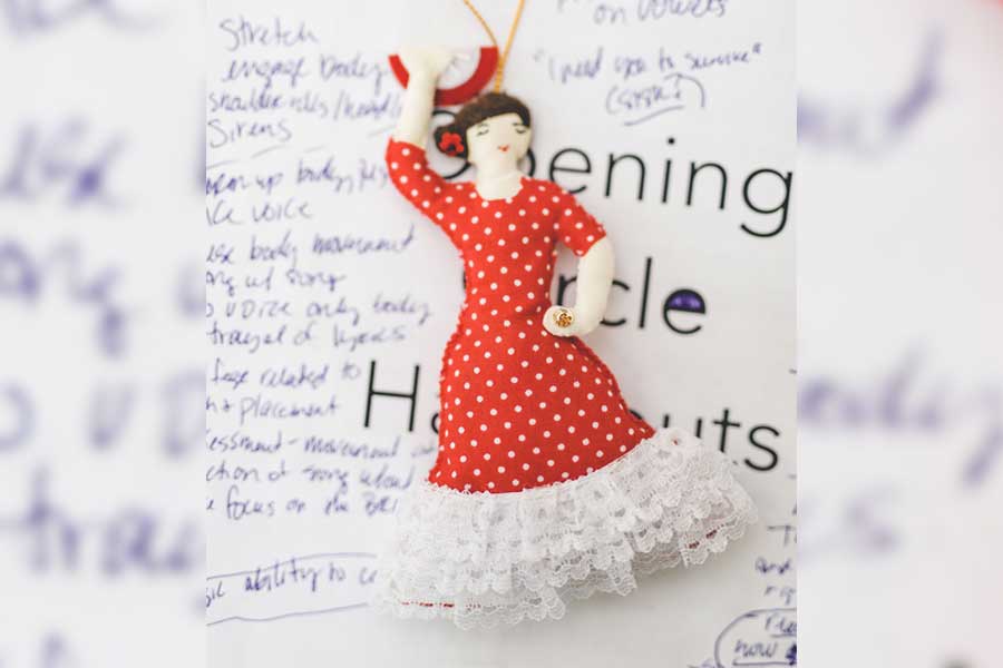 Small figure/ornament of dancing Carmen figure atop handwritten notes