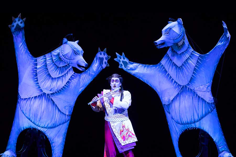Prince Tamino holds the magic flute, surrounded by giant blue bears; from the Metropolitan Opera's production