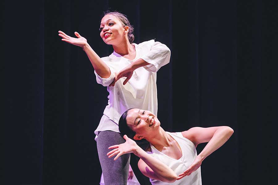 Two female dancers from Dayton Contemporary Dance Company do choreographed arm movements on stage
