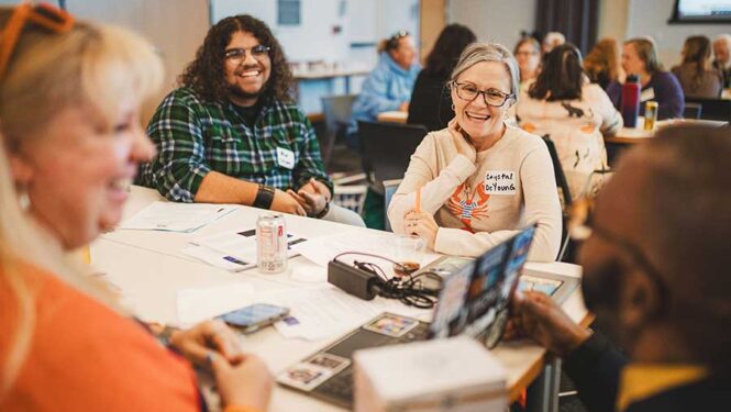 Staff, artists and students from Butler Tech SOA around a table laughing