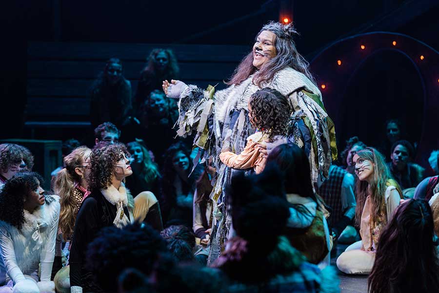 CATS production photo: Old Deuteronomy hugs a child, surrounded by the cast