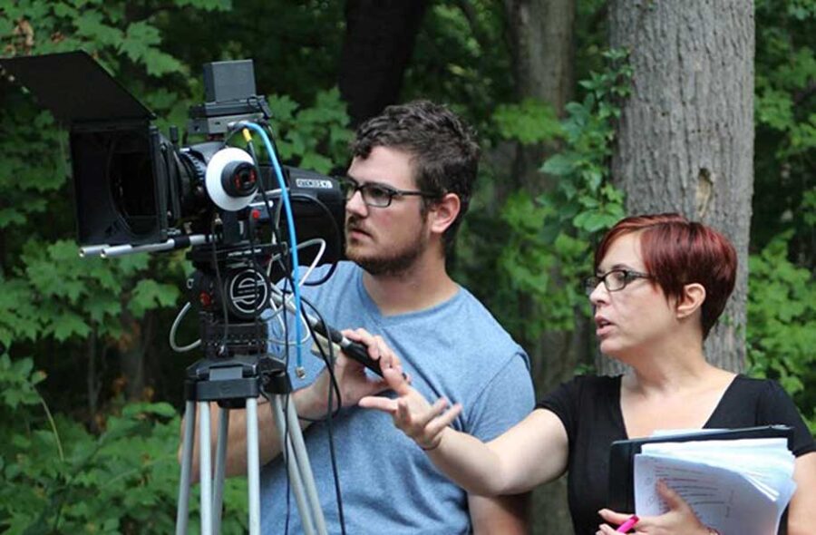 Nichol Simmons pictured with another person, both operating a camera
